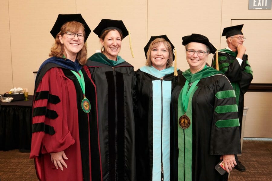 Faculty COMP-Northwest faculty posing for a photo prior to the ceremony