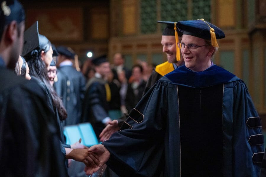 WesternU faculty shaking graduates' hands as they process to the PCA stage WesternU faculty shaking graduates' hands as they process to the PCA stage