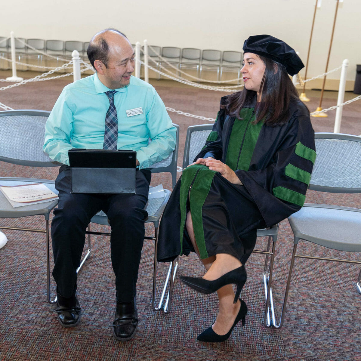 University staff member interviewing a DO graduate in Hall C prior to the ceremony. University staff member interviewing a DO graduate in Hall C prior to the ceremony.