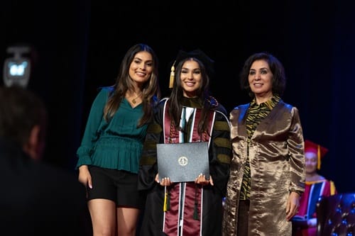 Family Hooder Photo A graduate he posing with their guests after just receiving their hood.